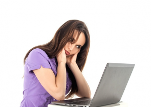 Tired young woman at computer
